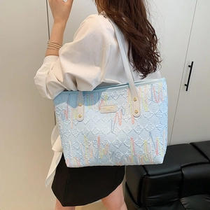 Light blue embossed leather tote bag with colorful embroidery and long white handles