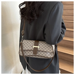 Vue détaillée du sac baguette rétro avec motif marron et boucle dorée élégante