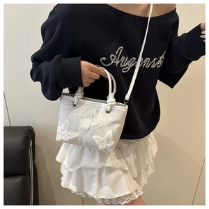 Detailed close-up of white Chinese style embroidery bucket bag with 3D butterfly appliques
