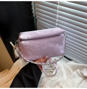 Detail of light purple snake print handbag with elegant silver chain and pearl decoration