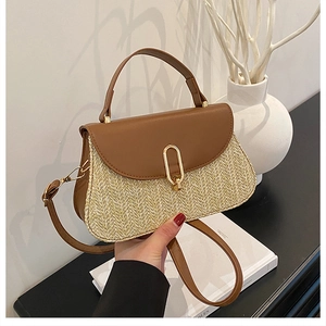 Detail of woven straw and brown leather crossbody bag with golden oval metal clasp