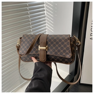 Gros plan du sac baguette vintage marron avec boucle en métal doré et détails en cuir