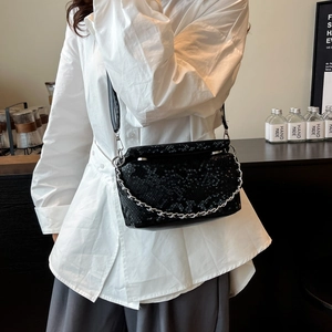 Fashionable black snake skin crossbody bag with silver chain detail on model