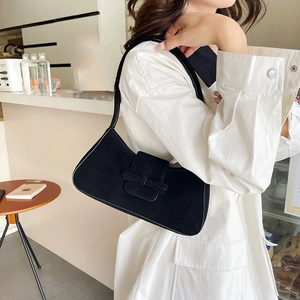 French retro black suede baguette shoulder bag shown on model in a cafe setting
