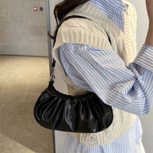 Minimalist black pleated cloud bag in soft leather with thin shoulder strap for women