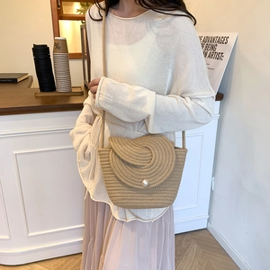 Straw woven crossbody bag with spiral flap and pearl closure for beach vacation style