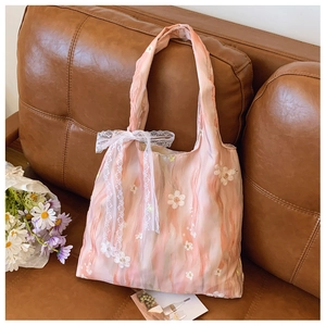 Close-up of pink floral canvas bag featuring 3D white flower embroidery and lace bow detail