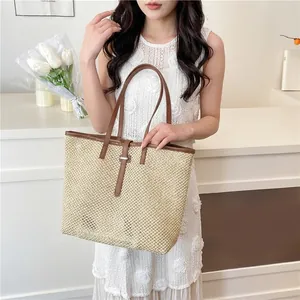 Hollow straw woven tote bag with brown faux leather straps and a large capacity for women