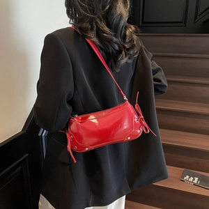 Fashionable red patent leather shoulder bag with chic metal studs and bow detailing