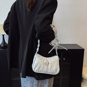Silver metallic butterfly underarm bag with crinkled texture and chic bow handle details