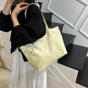 Minimalist beige tote bag featuring elegant lace bow and pearl tassel for women's daily commute