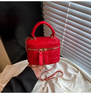 Dettaglio mini borsa trapuntata rossa con tracolla a catena dorata e doppia zip