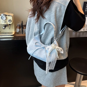 Hellblaue Halbmond-Handtasche mit Schleife und Perlenspitze auf der Schulter des Models