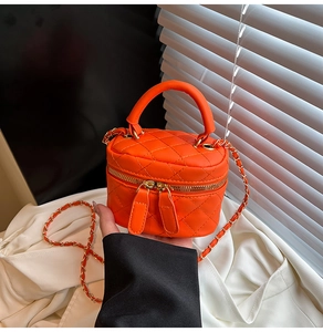 Dettaglio della trama trapuntata e delle doppie cerniere della mini borsa box arancione