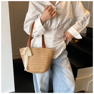 Detailed macro view of the woven straw texture and stylish white lace bow on the bag