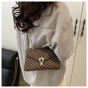 Détail du sac bandoulière rétro marron avec boucle fer à cheval dorée et bandoulière chaîne