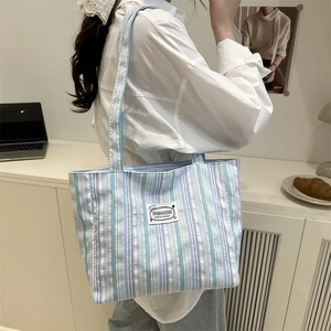 Vertical striped canvas tote bag in light blue and purple with fashion label patch