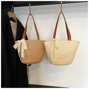 Detail of hand-woven straw beach bags with leather handles and lace bow decoration
