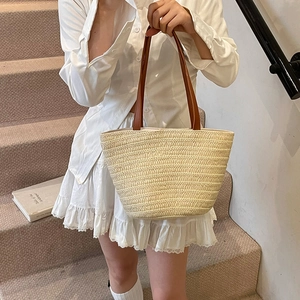 Handwoven straw tote bag with brown leather handles for summer fashion and travel