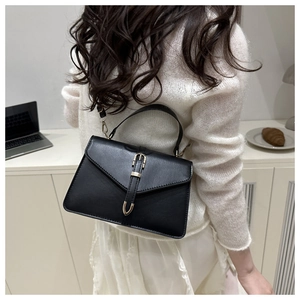 Vue arrière d'un mannequin portant un petit sac à bandoulière noir à boucle dorée