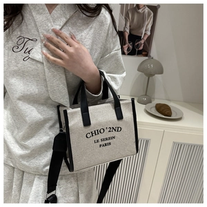 Détail du grand sac cabas en toile avec bordure en cuir noir et bandoulière tissée