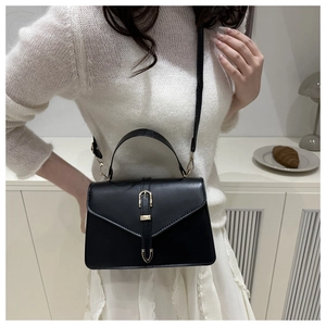 Détail du sac à main noir avec boucle dorée et bandoulière amovible pour femme chic