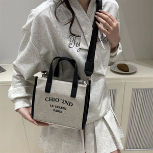 Sac fourre-tout minimaliste en toile beige avec finitions en cuir noir et bandoulière