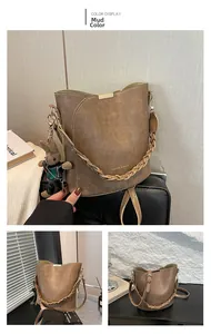 Detail of khaki brown bucket bag featuring woven handle and cute rabbit doll charm accessory