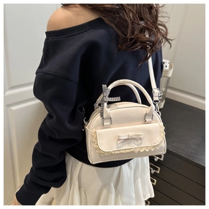 Détail du sac bandoulière en cuir PU blanc crème avec bordure dentelle et noeud