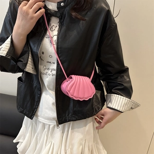 Pink shell-shaped crossbody bag with vertical stitching and matching leather strap