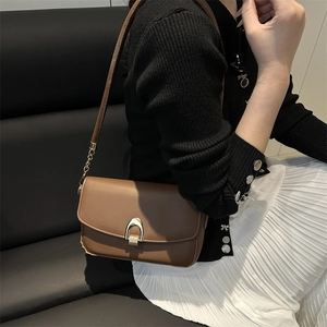 Elegant brown leather crossbody bag with gold horseshoe buckle and chain strap for women