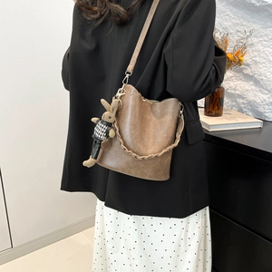 Vintage brown textured bucket bag with wide woven handle and cute rabbit charm pendant