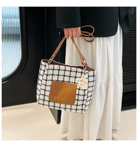 Dettaglio della borsa tote pied de poule con tasca in PU marrone e ciondolo gatto di peluche