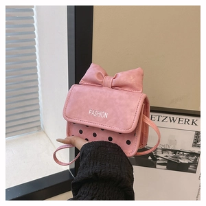 Detail of pink mini shoulder bag with large bow, black polka dots and fashion logo