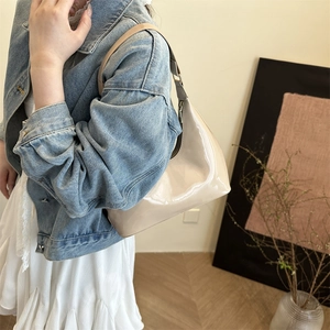 Minimalist beige patent leather hobo bag for women with shiny finish and adjustable strap