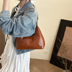 Brown glossy patent leather half-moon handbag with a stylish minimalist design for women