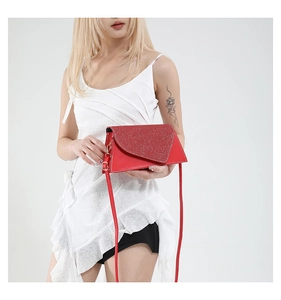 Detail of red geometric crossbody bag with sparkling sequins and smooth leather texture