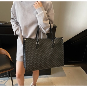 Détail du grand sac cabas gris avec motif M répété en cuir de haute qualité pour femme