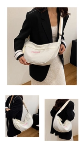 Detail of white nylon crescent bag with pink fashion lettering and adjustable wide strap