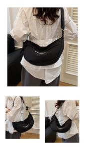 Detail showing large black fashion dumpling bag with adjustable strap and white text