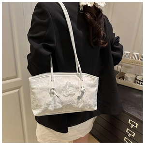 Detail of white lace shoulder bag featuring 3D butterfly embroidery and rope strap