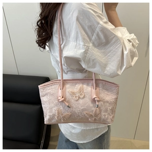 Detail of light pink shoulder bag with lace embroidery and 3D butterfly appliques