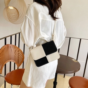 Minimalist black and white color-block leather square crossbody bag shown on a model
