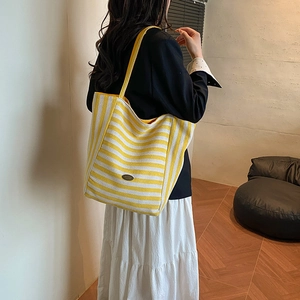 Grand sac cabas en toile à rayures jaunes et blanches dans un décor de style moderne