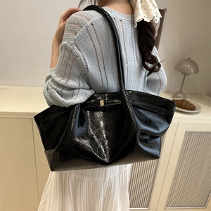 Minimalist large black glossy oil wax leather tote bag with pleated texture and gold buckle