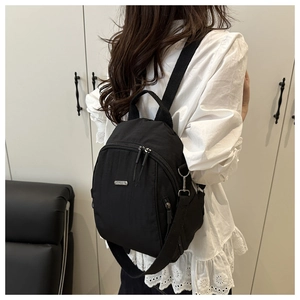 Detail of black nylon multi-way mini backpack with silver zippers and side pocket