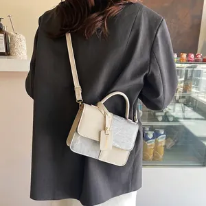 Modern two-tone crossbody bag in cream and silver marble finish with crossbody strap
