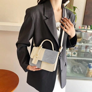 Modern two-tone top handle bag in beige and blue-grey leather with adjustable strap