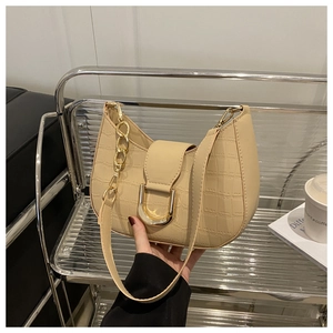 Detail of beige faux crocodile leather shoulder bag with gold metal U-shaped buckle