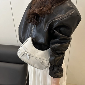 Retro metallic silver hobo bag with a stylish bow buckle and chain strap on model